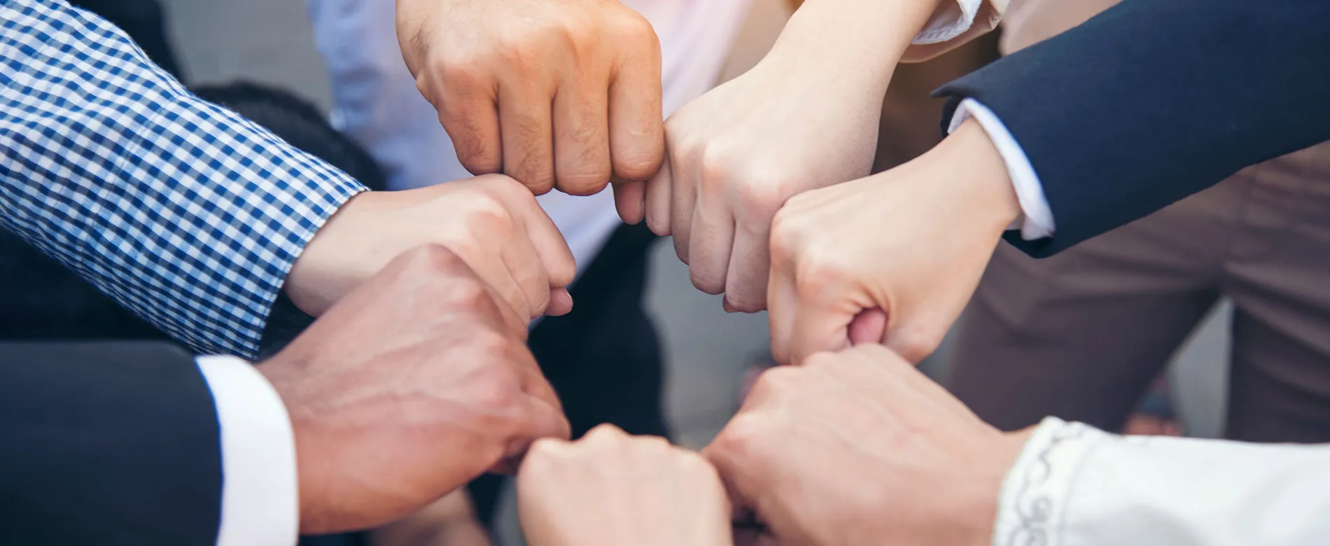 Several people standing in a circle bumping fists
