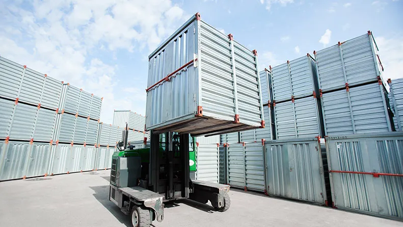 Outdoor storage area with containers and forklift