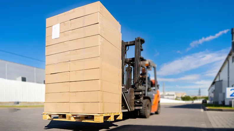 Forklift truck loaded with pallet and cardboard boxes