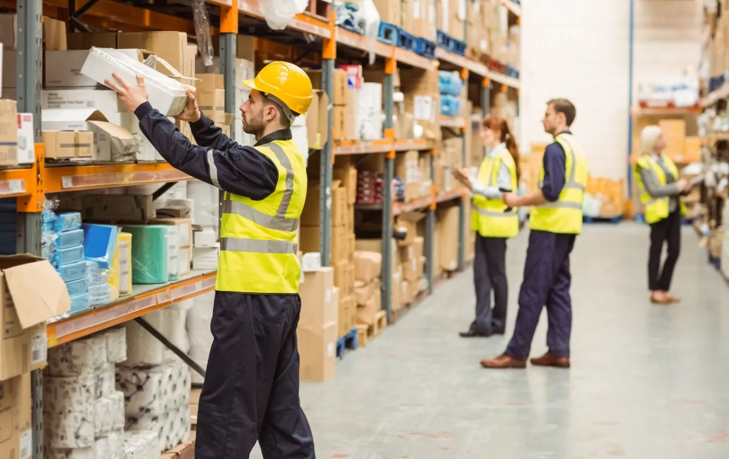 workers in a logistics warehouse using RFID technology to track goods