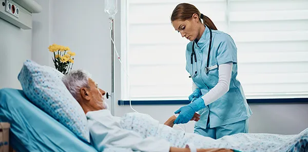 Hospital nurse next to patient's bed with automated contract tracing 