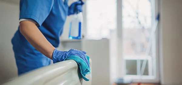 Nurse disinfecting hospital bed