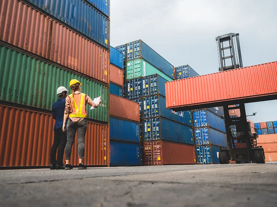 Workers looking at containers at an outdoor storage yard
